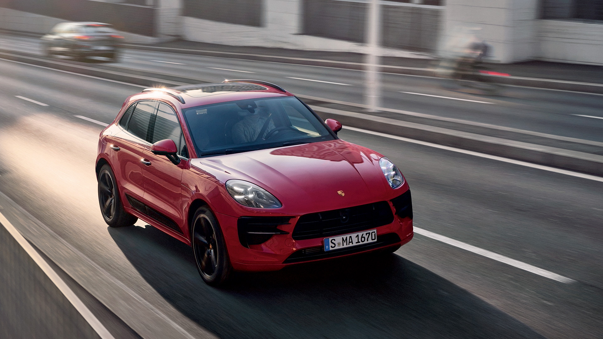 Porsche Macan on an urban highway. Used to illustrate the article, "5 Reasons Not to Delay Paintless Dent Repair in Denver."